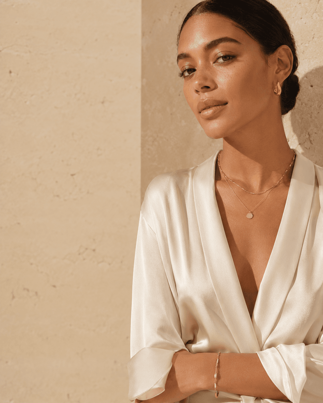Woman wearing layered VOW 47 gold jewelry